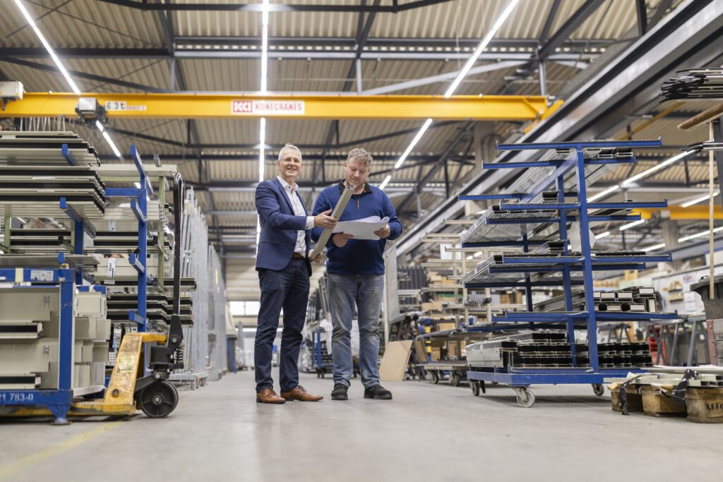 Zwei Ingenieure In Der Werkhalle Von Dodel Metallbau Besprechen Ein Projekt.