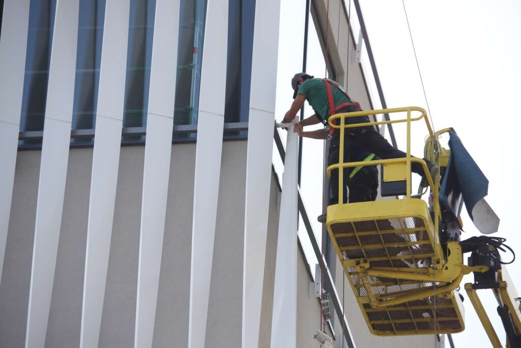 Arbeiter An Glasfassade Auf Hebebuehne