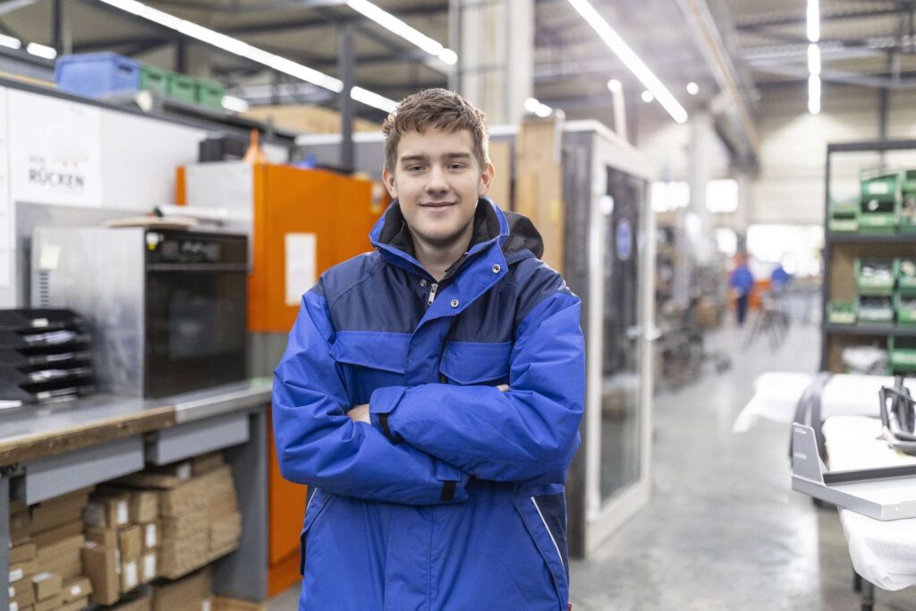 Mitarbeiter der Dodel Metallbau GmbH in der Werkstatt mit blauer Arbeitsjacke.