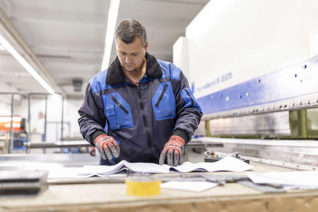 Mitarbeiter Der Dodel Metallbau Gmbh Prueft Unterlagen In Der Werkstatt.